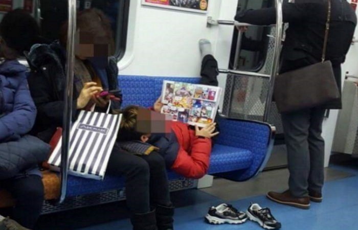 지하철에서 엄마 무릎 베고 누워 만화책 보는 아들