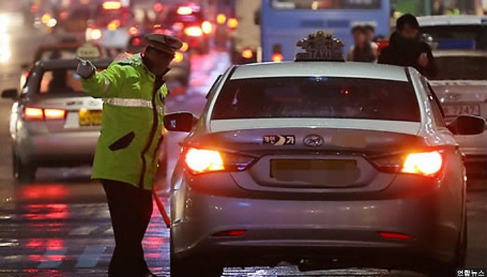 경찰관 매달고 도주한 불법 택시 운전자 중형