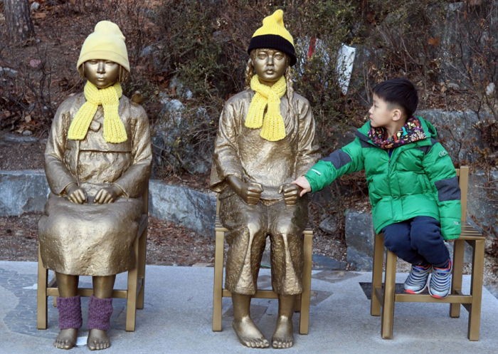 추운날 차가운 소녀상 손을 꼭 잡아주는 어린아이