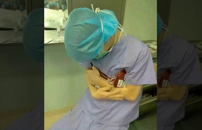 수술실서 수혈 받을 환자 위해 혈액 끌어안은 의사 (사진)