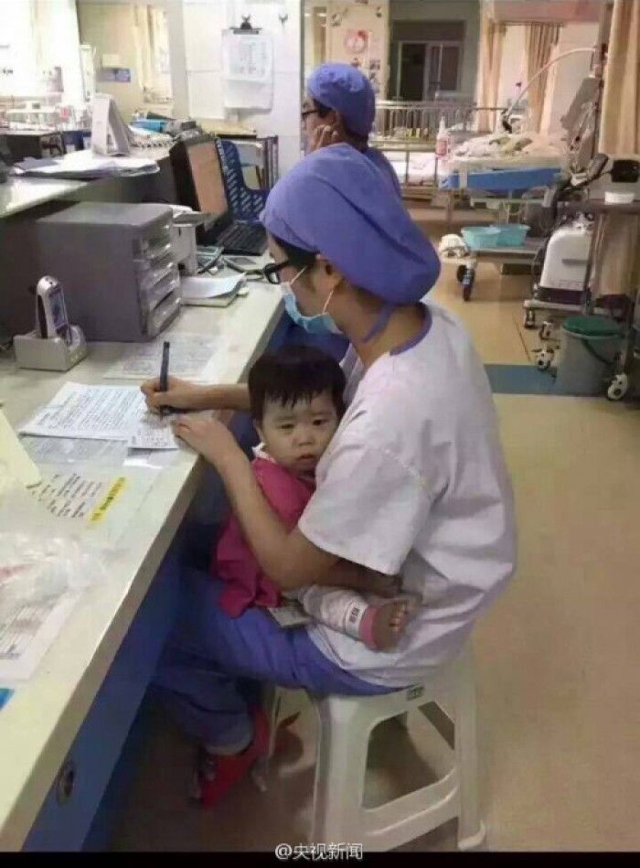 겁에 질린 ‘고아 소녀’ 품에 안고 업무보는 간호사 (사진)