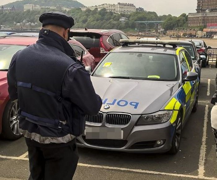 경찰차에 벌금 딱지 붙이는 교통 경찰관