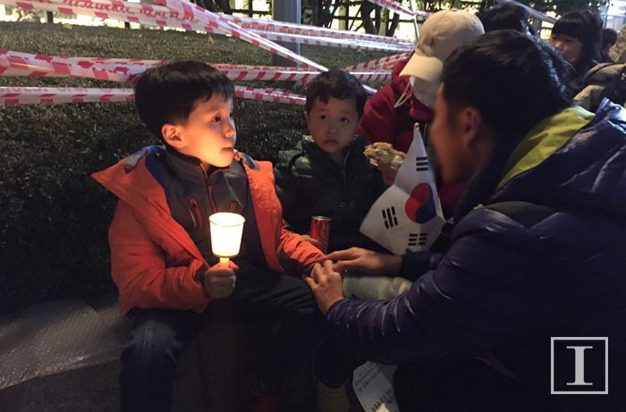 아이들에게 촛불집회에 대해 설명하는 아빠