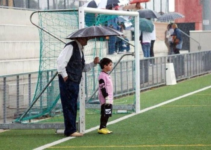 비오는 날 축구하는 손자 감기 걸릴까봐 우산 들고 서 있는 할아버지