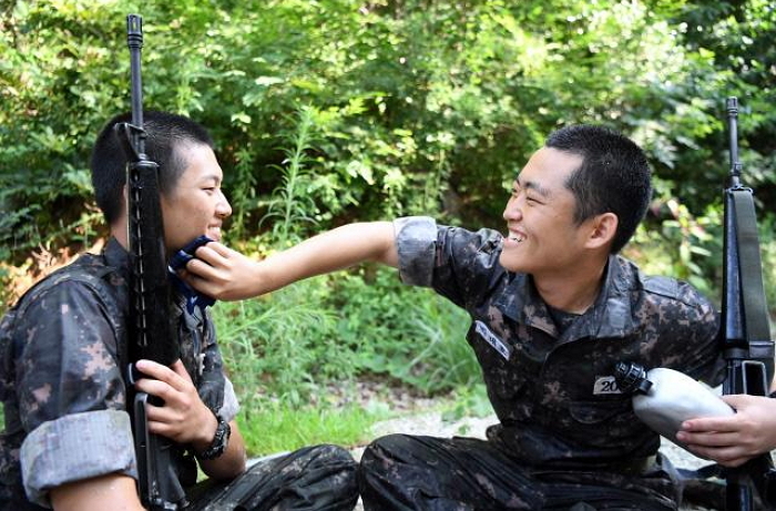 훈련 중 총기 들고 휴식하는 전우 땀 닦아주는 훈련병