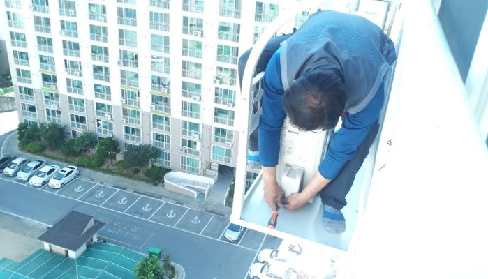 고층 아파트 난간에서 ‘맨몸’으로 에어컨 실외기 설치하는 기사들