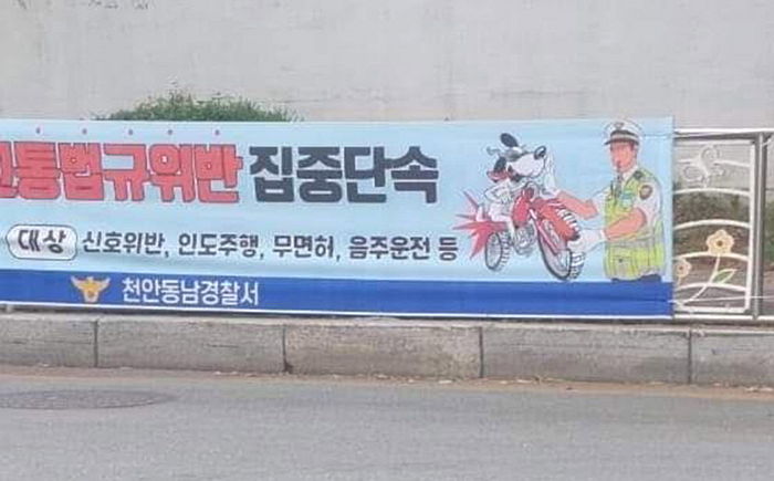 경찰이 오토바이 운전자를 ‘개’로 묘사한 현수막 달자 “내려라” 항의한 라이더 노조