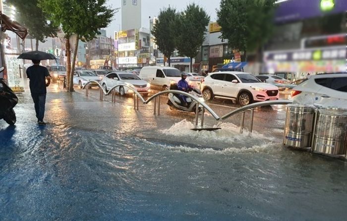 폭우 속 ‘뻥 뚫린’ 맨홀 앞 지키며 위험 알린 시민, ‘배달 라이더’였다