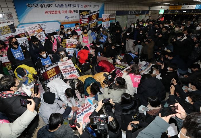 출근길 시민들 몰려드는 지하철역에서 신년 맞이 세배 인사하는 전장연 회원들