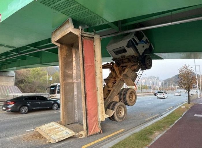 적재함 안 잠그고 달리다 교량 밑에 수직으로 낀 덤프트럭