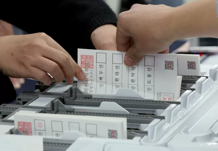 지난달 13일 모의개표 실습에 참여한 각 구별 선과누이 직원들이 투표지분류기에 투표지가 걸린 상황을 대처하고 있다. / 뉴스1