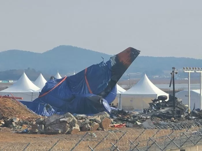 12일 오전 무안국제공항 활주로 인근에는 제주항공 여객기 동체가 천에 쌓여 있다. / 뉴스1