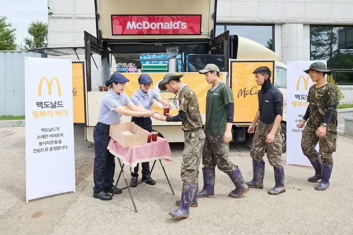 [보도사진1] 가평 지역 수해 복구에 참여한 군 장병들이 맥카페 음료트럭 앞에서 버거와 음료를 수령하고 있다.jpg