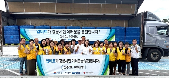 [사진자료2] 업비트가 강릉시에 생수 100만병을 기부, 대한적십자사 강릉지구봉사원 관계자들과 함께 기념 촬영을 하고 있다..jpg