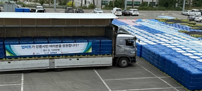 [사진자료3] 업비트가 강릉시 가뭄 위기 극복을 위해 기부한 생수 100만병이 강릉올림픽파크아레나경기장에 내려지고 있다..jpg