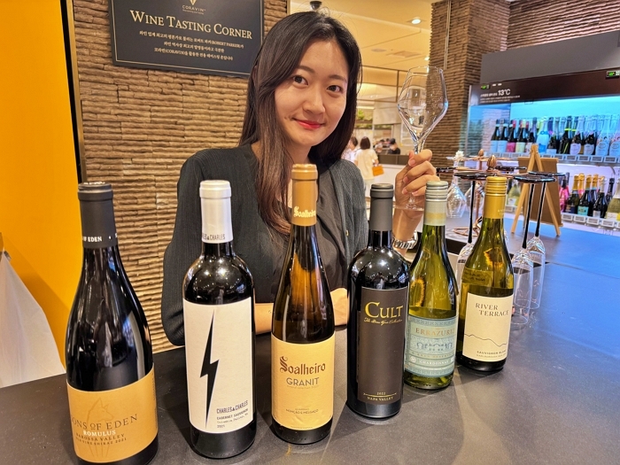 [롯데쇼핑-롯데백화점] 소공동 본점 와인 매장에서 모델이 '더 블라인드 서울의 심판 2025' 수상 와인을 선보이는 모습2.jpg