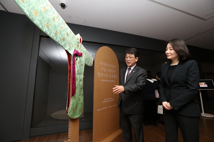 2511_보도사진_최응천 국가유산청장(왼쪽)과 이홍주 LG생활건강 상무(오른쪽)가 지난 4월 서울 국립고궁박물관에서 열린 ‘조선 왕실, 대한제국 황실 국가유산 복제 성과 공개 행사’에서 영친왕비가 입었던 소례복(당의) 복.jpeg
