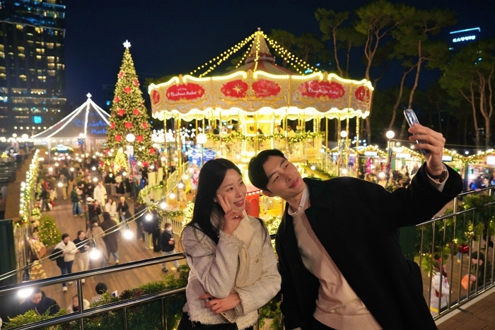 4. [롯데백화점] 롯데타운 잠실 '크리스마스 마켓'에서 '2층 회전목마'와 '초대형 크리스마스 트리' 를 배경으로 사진을 찍는 모델.JPG