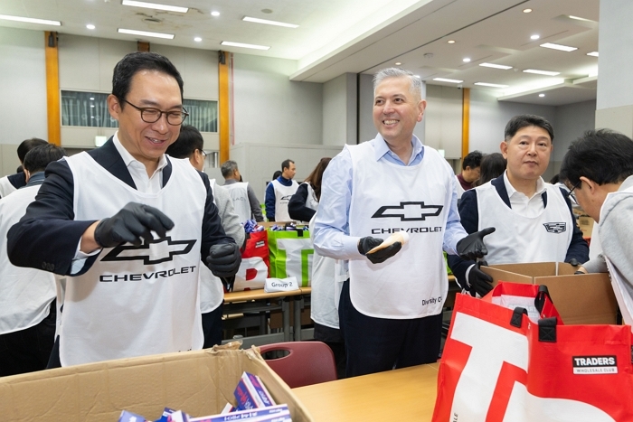 [사진 4] 선물상자를 제작하고 있는 GM 한국사업장 임직원들과 협신회 회원사 대표 및 임직원들. (왼쪽부터) 헥터 비자레알 GM 한국사업장 사장(2번째), 허우영 GM 한국사업장 협신회 회장(3번째).jpg