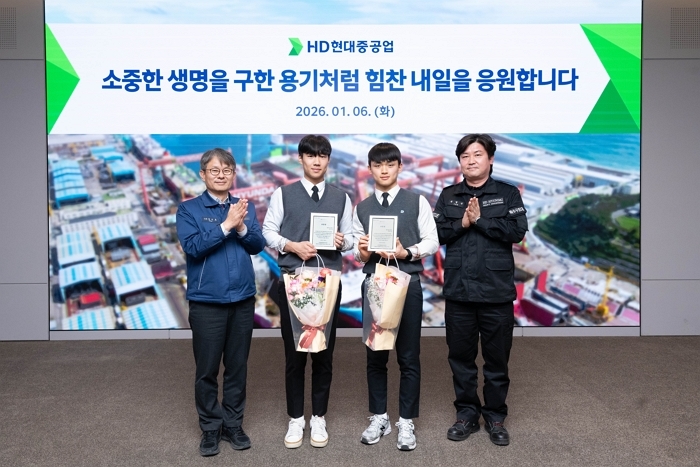 HD현대중공업이 시민의 생명을 구한 직원 자녀 등 학생 2명을 회사로 초청해 표창장과 장학금을 전달했다. (사진 왼쪽부터 HD현대중공업 금석호 사장, 문현서 군, 윤재준 군, HD현대중공업 윤형민 기사).jpg