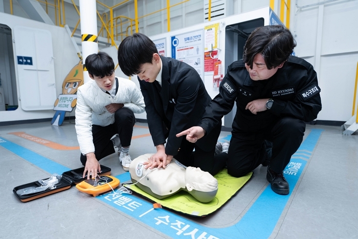 HD현대중공업 안전체험관에서 윤형민 기사가 윤재준 군과 문현서 군에게 특별 안전 교육을 실시하고 있다..jpg