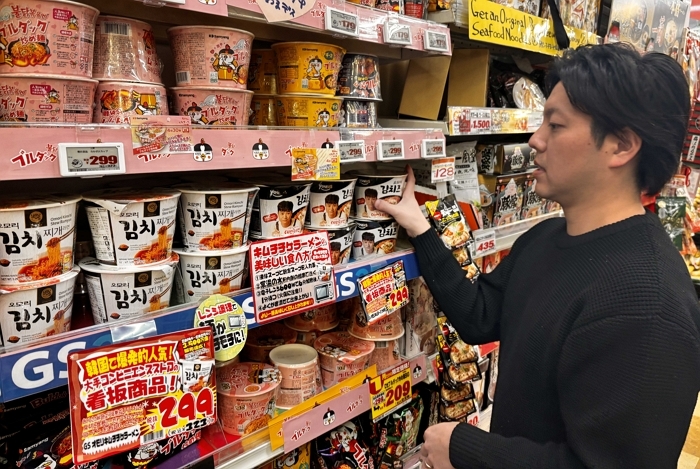 [첨부3]GS25가 PB라면 '오모리' 시리즈를 일본 돈키호테로 수출했다. 고객이 일본 돈키호테 매장에서 '오모리' 시리즈를 살펴보고 있는 연출 이미지.jpg