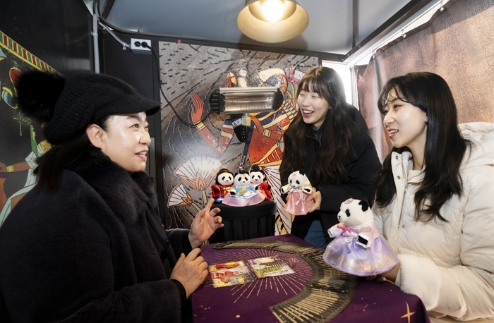 2. 에버랜드 타로점에서 모델들이 신년 바오패밀리 굿즈와 함께 타로를 체험하고 있다.jpg