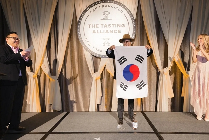 [사진자료 3] SFWSC 2025에서 상을 받은 뒤 태극기를 펼친 도정한 기원 위스키 대표.jpg