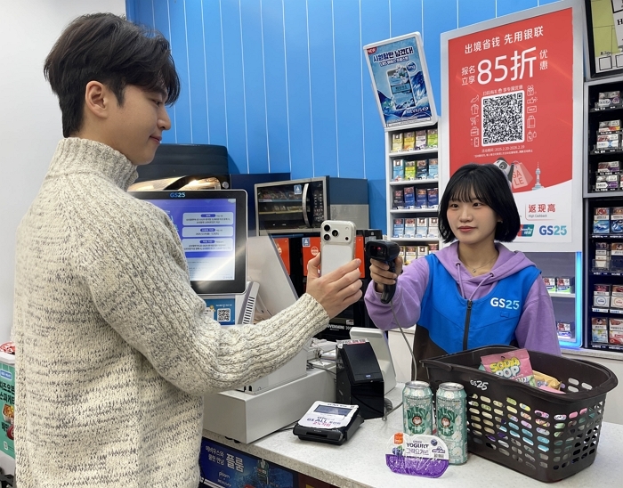 [이미지2[ GS25에서 고객이 모바일 기반 간편결제를 이용해 상품을 구입하고 있다..jpg