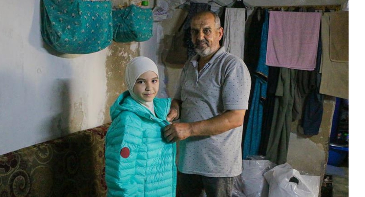 사진3_지진으로 피해를 입은 시리아 소녀가 영원무역그룹이 후원한 의류를 전달받는 모습..jpg