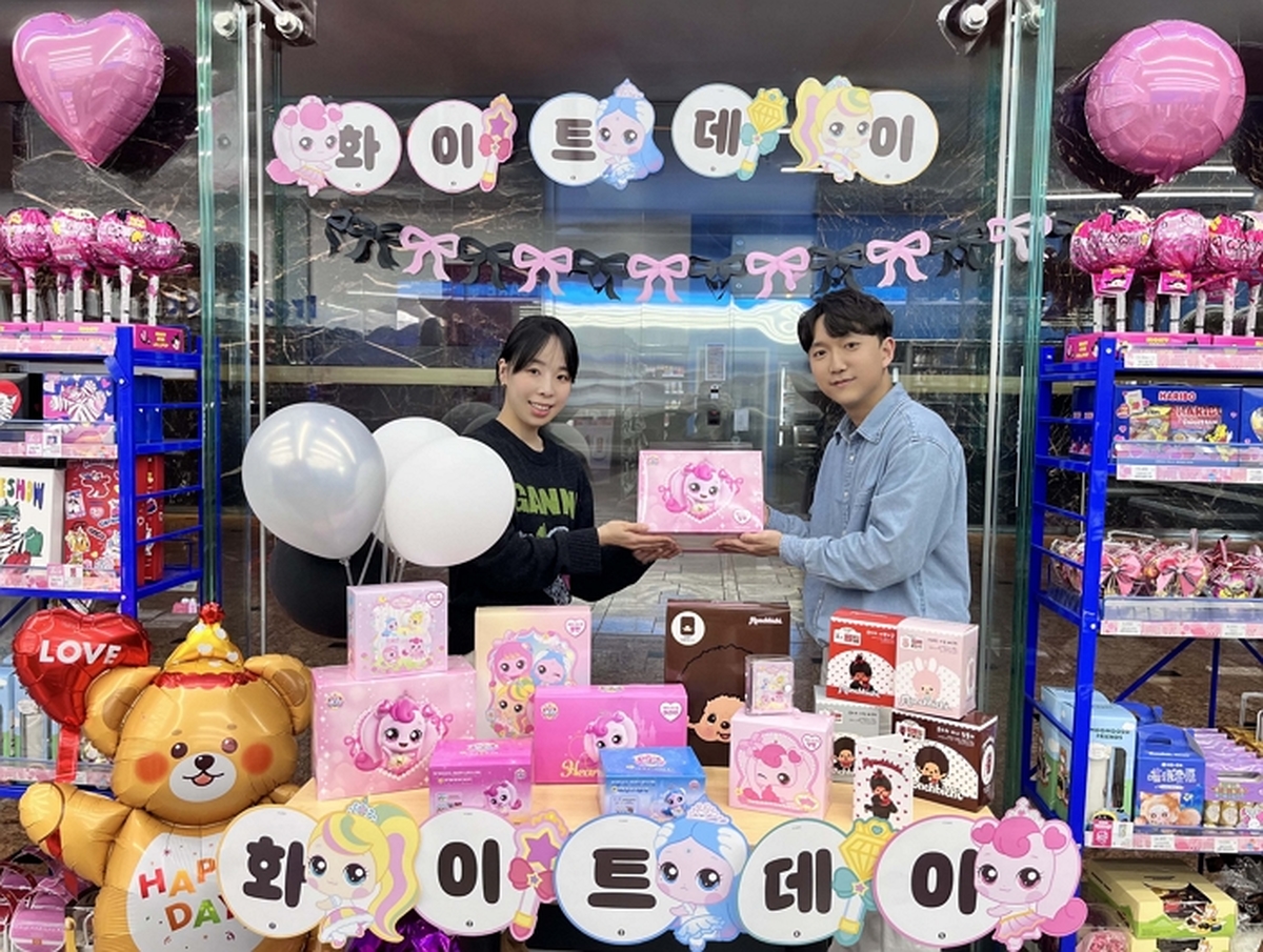 [사진자료1] GS25에서 모델이 화이트데이 행사 상품 앞에서 포즈를 취하고 있다.jpg