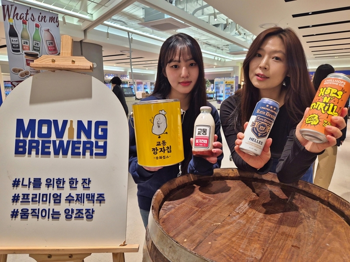 1. [롯데백화점] 평촌점 지하1층에서 진행 중인 '무빙브루어리' 팝업스토어에서 모델이 상품을 들고 있다.jpg