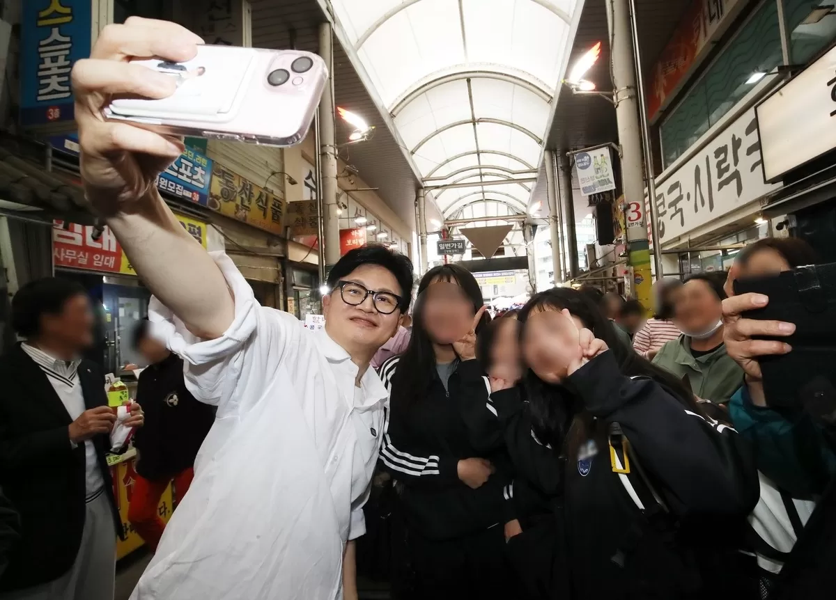 한동훈 전 국민의힘 대표가 29일 오후 부산 북구 구포시장을 찾아 학생들과 셀카를 찍고 있다 / 뉴스11