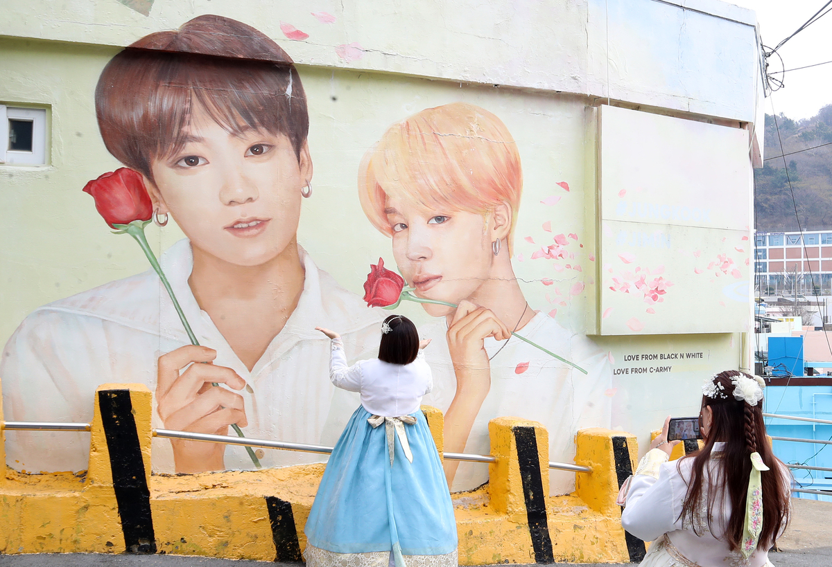 방탄소년단(BTS) 컴백 공연을 이틀 앞둔 19일 부산 서구 감천문화마을에서 외국인 관광객들이 부산이 고향인 BTS 멤버 정국·지민이 그려진 대형 벽화를 배경으로 기념촬영을 하고 있다. 2026.3.19/뉴스1