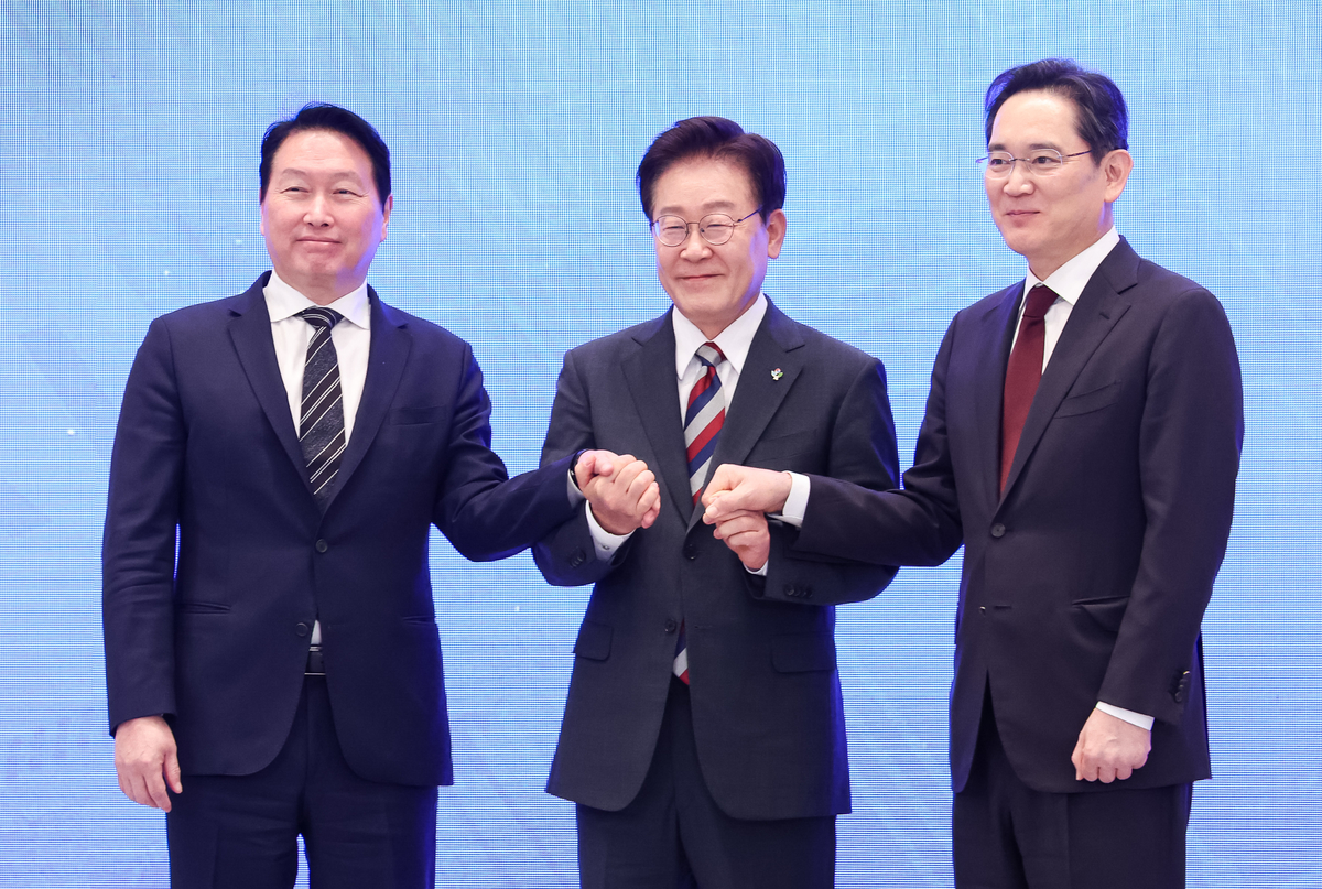 이재명 대통령과 이재용 삼성전자 회장, 최태원 SK그룹 회장이 29일 청와대 영빈관에서 열린 대한민국 대도약 3대 메가프로젝트 국민보고회에서 손을 맞잡고 있다. 2026.6.29/뉴스1