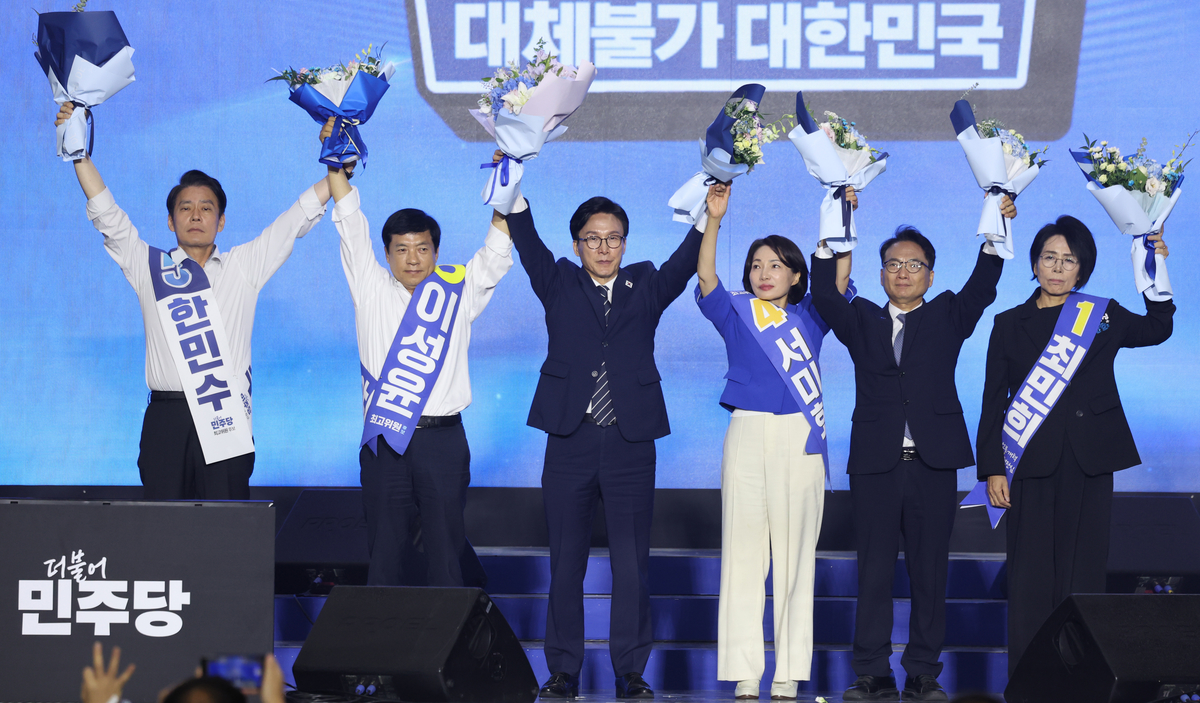 더불어민주당 김민석 신임 당대표가 17일 대전시 유성구 대전컨벤션센터에서 열린 더불어민주당 제3차 정기전국당원대회에서 최고위원들과 함께 손을 들고 인사하고 있다. 왼쪽부터 한민수, 이성윤 최고위원, 김 대표, 서미화, 박선원, 최민희 최고위원. (공동취재) 2026.08.17 2026.8.17/뉴스1