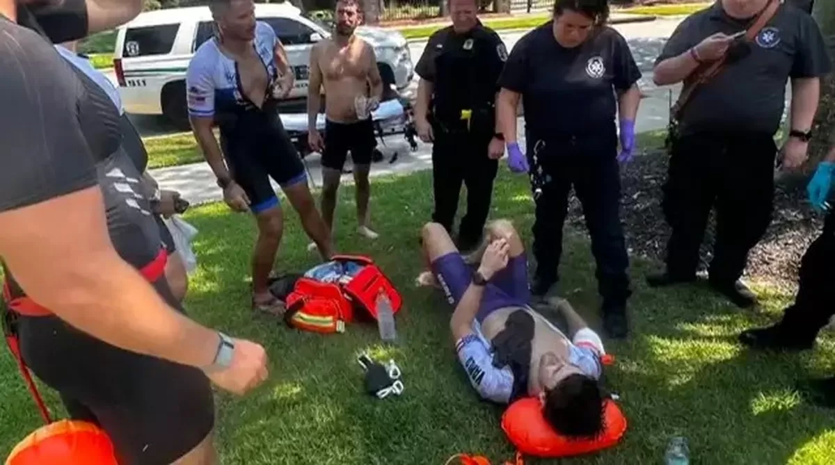 Jonathan Bruney, a triathlon coach, lying on the grass after an alligator attack, surrounded by p...