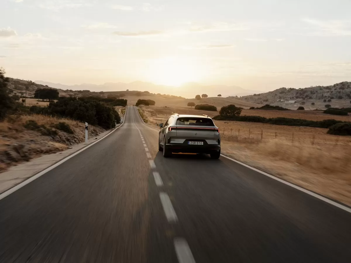 Polestar 4 SUV driving down country road at sunset