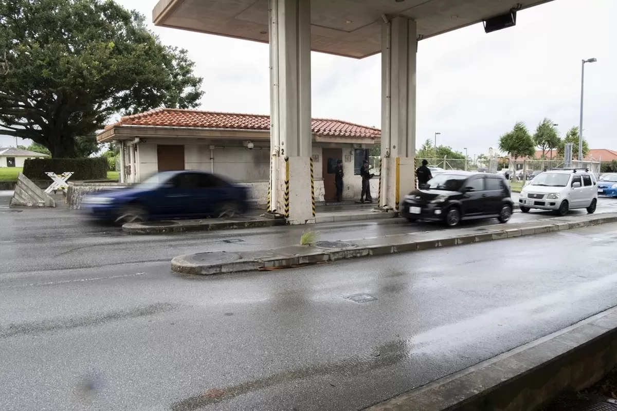 The image shows a security checkpoint or gate facility with multiple vehicle lanes under a covere...